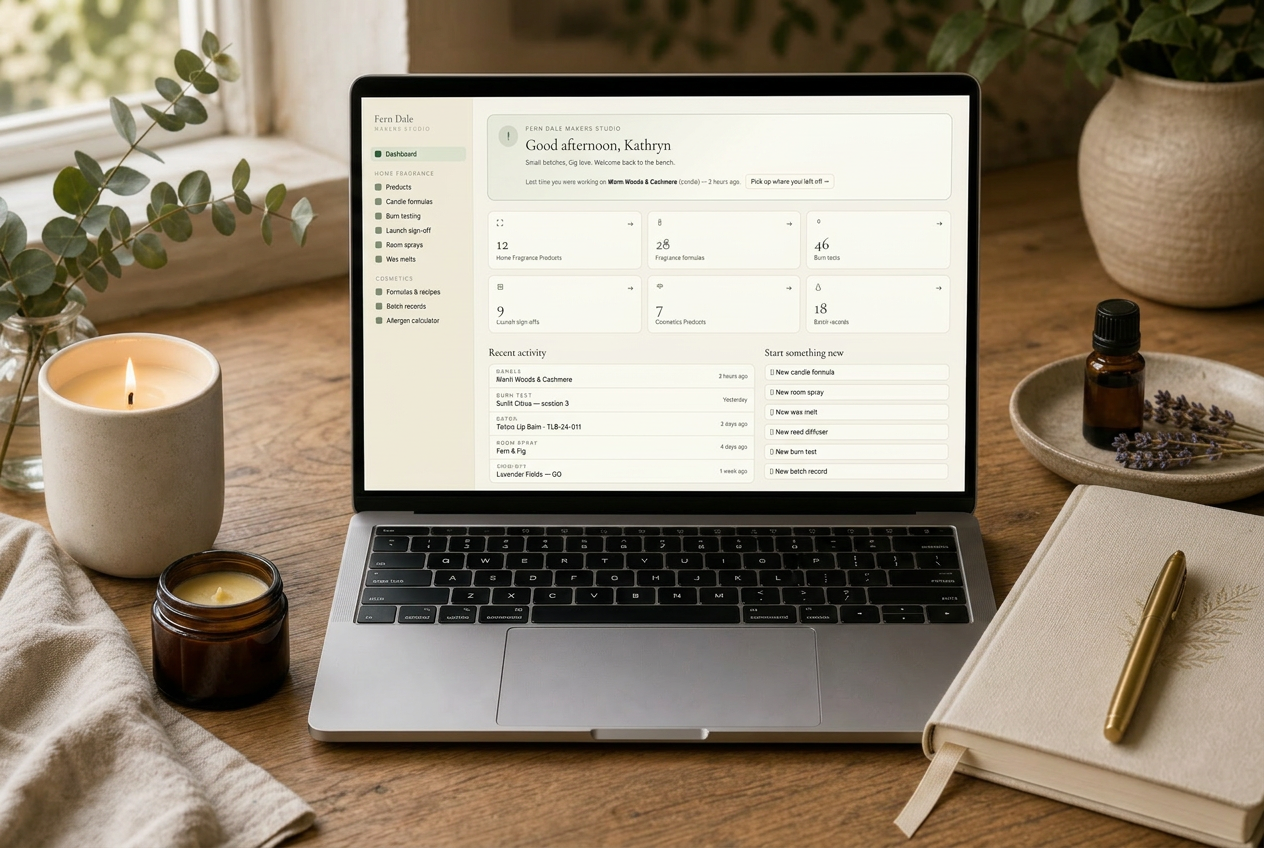 A calm desk scene with a lit candle, open notebook and a laptop showing the Fern Dale Makers Studio dashboard.