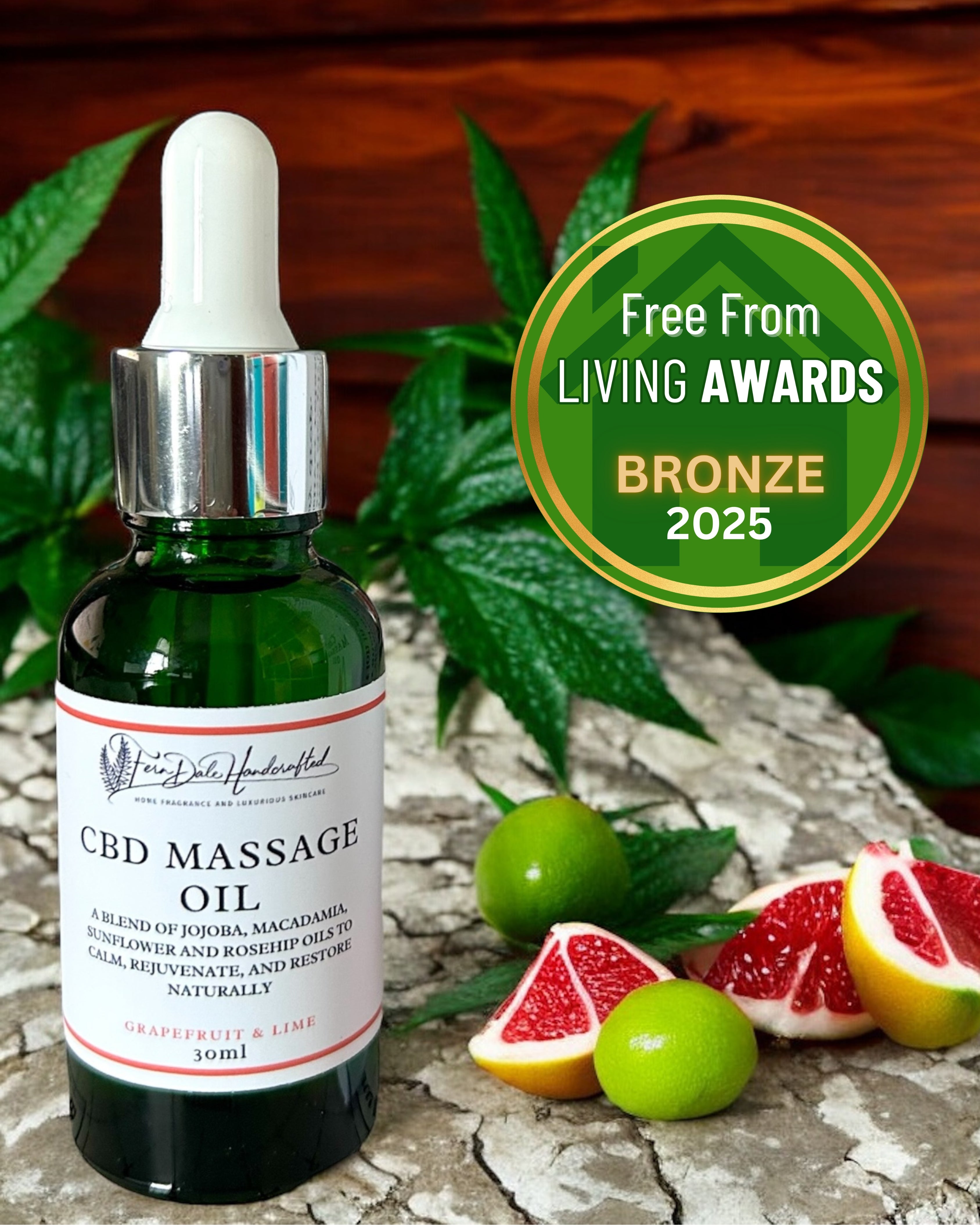 Massage Oil in Grapefruit & Lime in a green dropper bottle beside citrus pieces and a bronze 2025 awards badge.