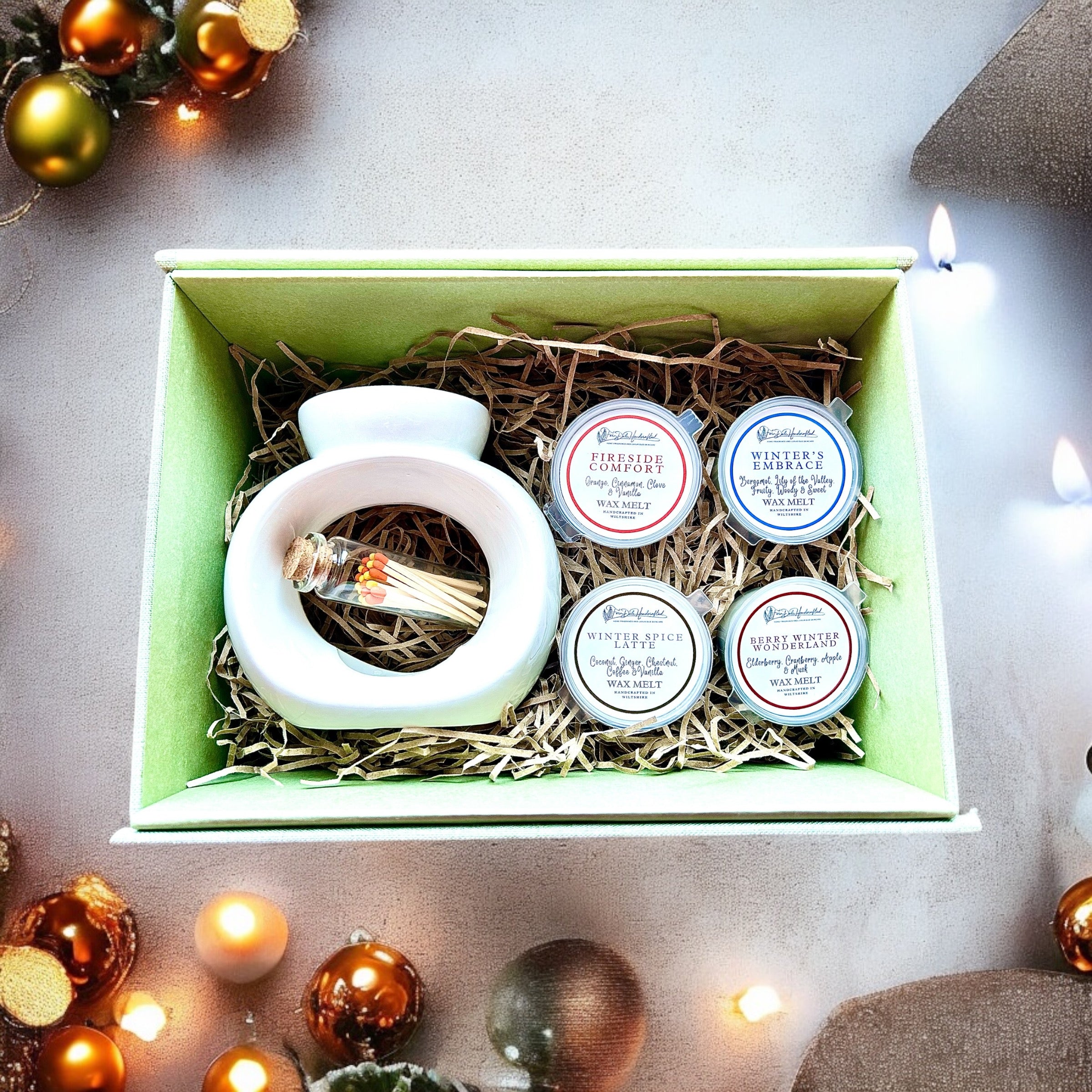 Ceramic Wax Melter and Melts Gift Set with a white melter, four melt pots and bottled matches in a green box.