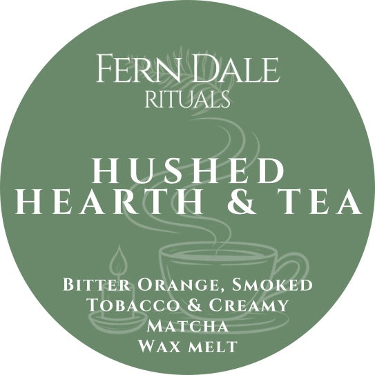 Hushed Hearth & Tea round green wax melt label with white lettering and line drawings of a steaming cup and candle.