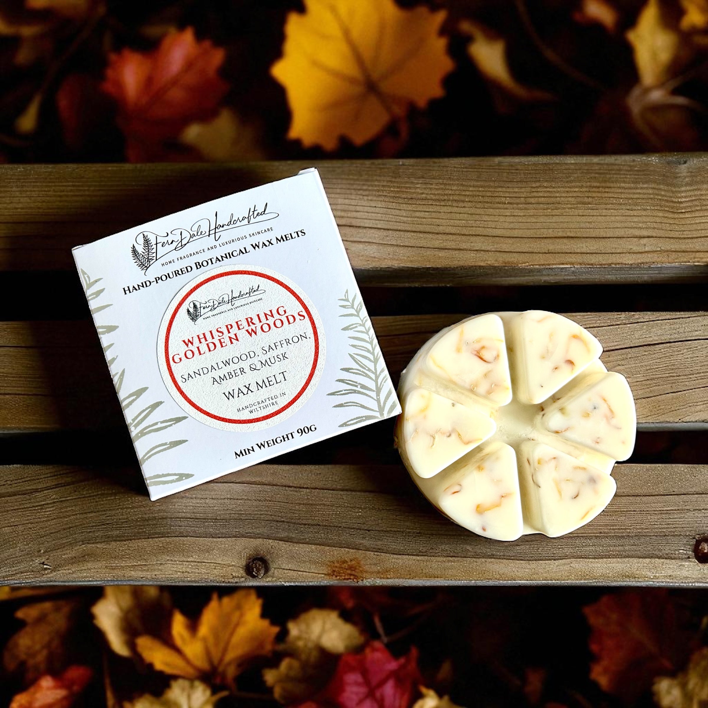Wheely Big Wax Melts in a cream six-segment wheel beside a white box on wooden slats, surrounded by autumn leaves.
