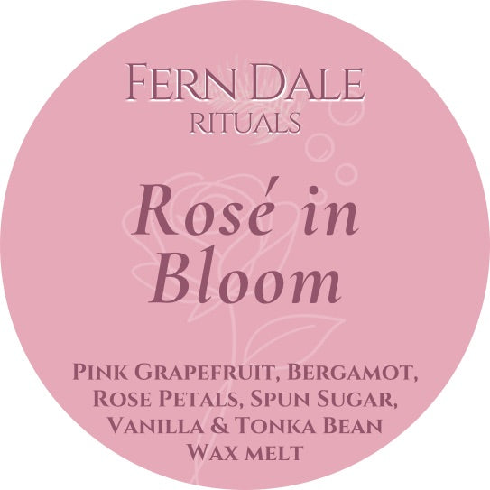 Rosé in Bloom round pink wax melt label with burgundy lettering and a faint rose outline.