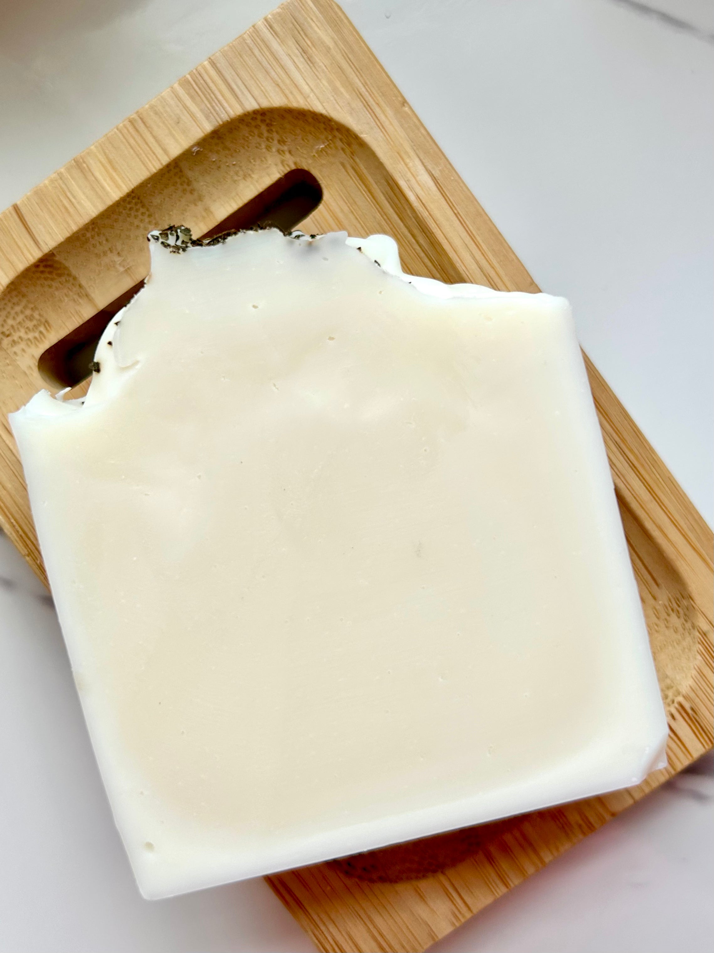 Whisper Leaf - Lemon, Fir, Peppermint & Eucalyptus (Air) Tallow Soap, a cream bar on a slotted wooden dish.